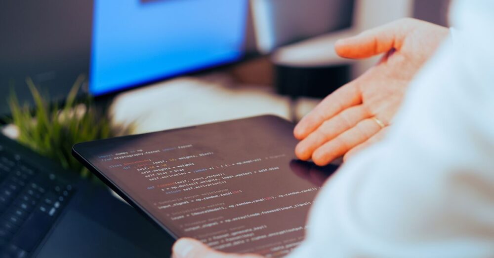 AIが生成したECサイトのソースコードと、横に並べられた法的書類やセキュリティチェックリストを、開発者が真剣な表情で確認している様子。