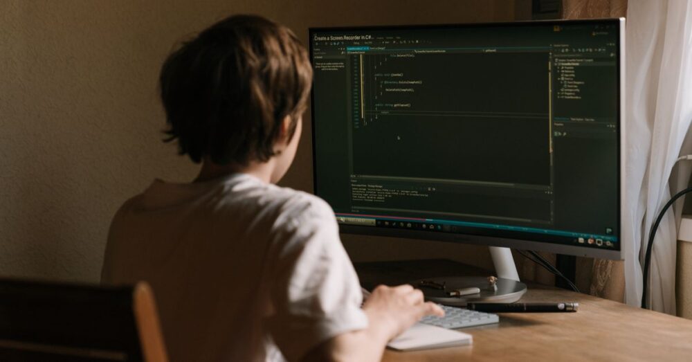 AIが生成したECサイトのソースコードと、横に並べられた法的書類やセキュリティチェックリストを、開発者が真剣な表情で確認している様子。