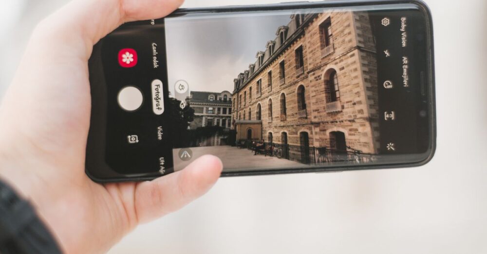 スマートフォンの画面越しに広がる、明るく開けた未来の都市の風景。AI技術が人々の生活をより豊かで知的なものへと導くイメージを象徴している。