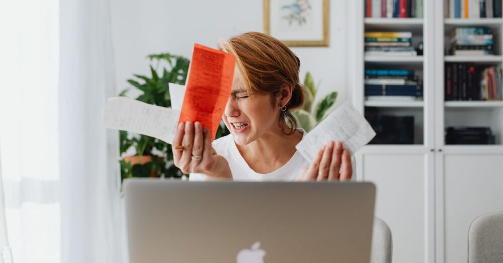 パソコンの前で難解なニュース画面を見て少し困った表情を浮かべる、50代の落ち着いたビジネスパーソン。