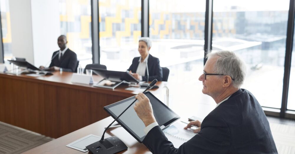 高層ビルのオフィスで、重要な交渉や意思決定を行うビジネスパーソン。AIをツールとして使いこなし、高度な人的スキルに集中するアップスキリングの様子。