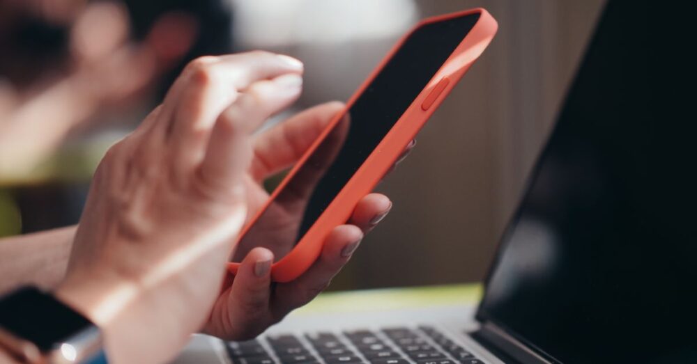 スマートフォンを操作しAIを活用して生産性を向上させているビジネスパーソンの手元のイメージ