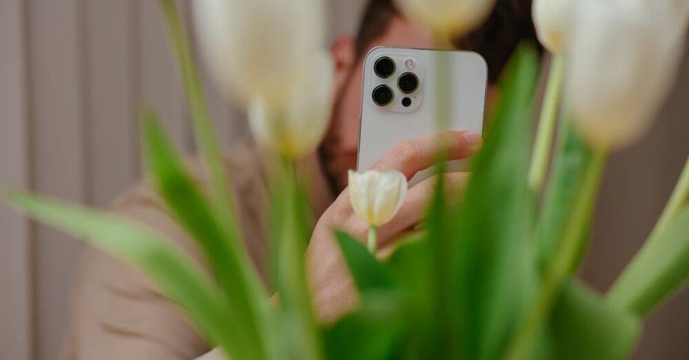 ホワイトボードに書かれた会議メモをスマートフォンのカメラで撮影している様子。アナログ情報をAIに取り込むための初動を表現している。