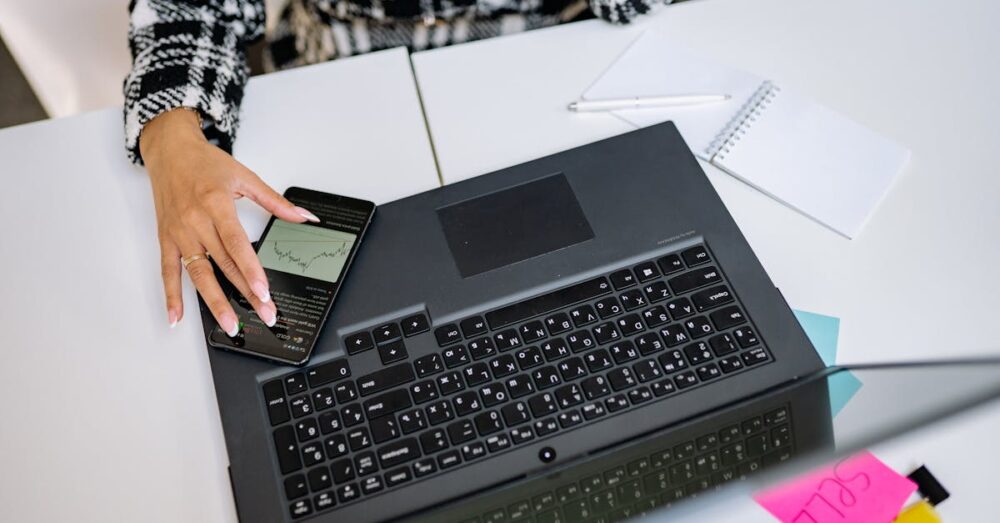 スマートフォンとノートPCが同期し、AI音声入力データがスムーズに連携している洗練されたオフィスのイメージ