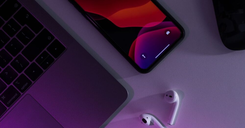 スマートフォンとノートPCが同期し、AI音声入力データがスムーズに連携している洗練されたオフィスのイメージ