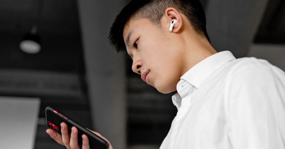 外出先でスマートフォンに向かって小声で話し、AIが音声を正確に捉えて波紋のように広がるイメージ